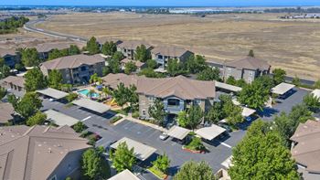 Aerial view of apartment complex with surrounding open land